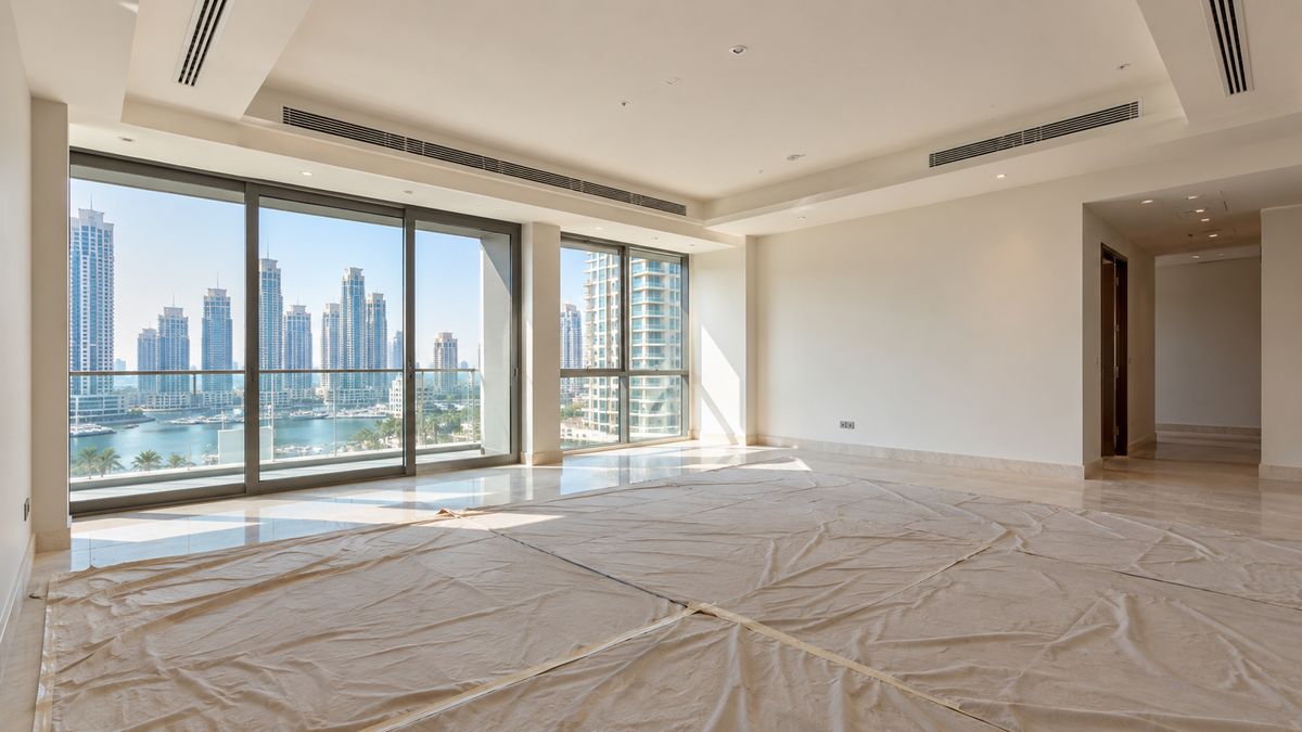 Freshly renovated empty Dubai living room with ceiling vents and dust sheets